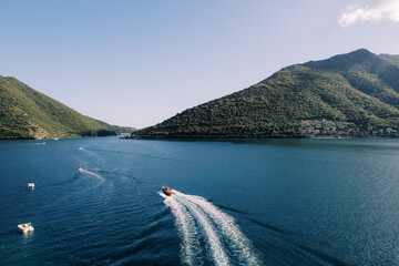 Rapid speedboat streaks across azure waters toward distant coastlines © VolodymyrNadtochii