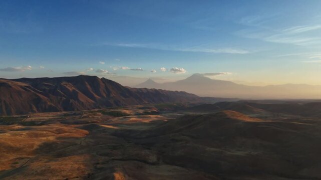 Aerial shot of rocky foothills and open valley with Mount Ararat in the background near Garni, Armenia.