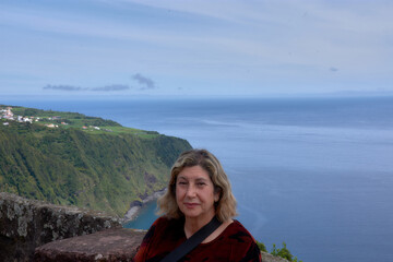 Fototapeta premium Beautiful woman enjoying scenic views at the iconic Miradouro da Ponta Madrugada, Azores.