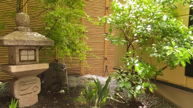 石灯籠と竹垣のある和風の庭の風景