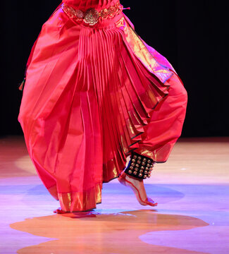 A Bharatanatyam dance artist in traditional saree wearing Ghungroo or metallic bells strung together to form musical anklets.