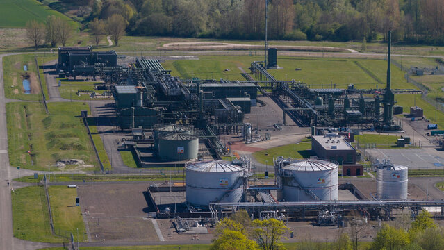 Aerial view of the NAM Grijpskerk UGS facility featuring large storage tanks and intricate industrial piping systems surrounded by green fields in Grijpskerk, Groningen, Netherlands.