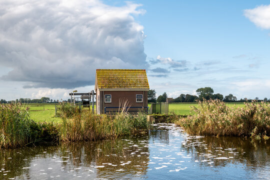 Small electric pumping station used for polder drainage along Wijde Wijmerts waterway, Friesland, Netherlands