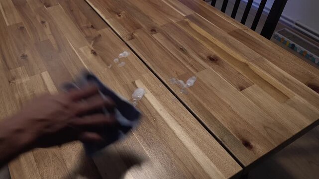 person cleaning the dining table with a dishcloth and disinfectant. High quality 4k footage