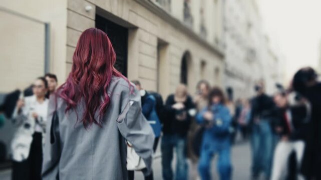 Stylish woman with pink hair walking at fashion week
