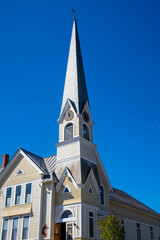 Fototapeta premium Historic church steeple with clock tower reaching blue sky