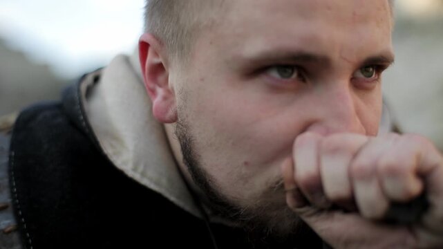 Extreme close-up of medieval warrior's hand picking up dark soil and bringing it to face to smell. Intense primal tracker detail shot with shallow depth of field &mdash; dramatic historical action footage.