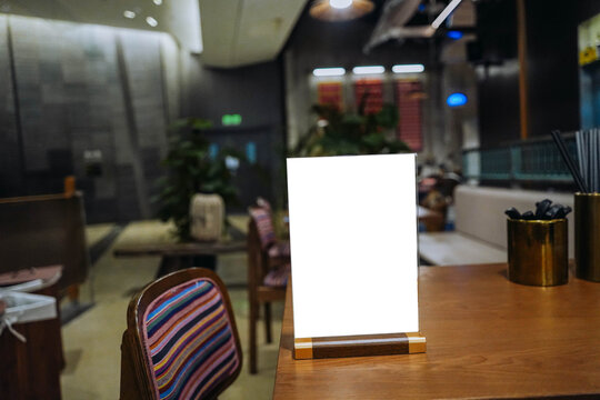 Mock up Menu frame standing on wood table in Bar restaurant cafe. space for text.