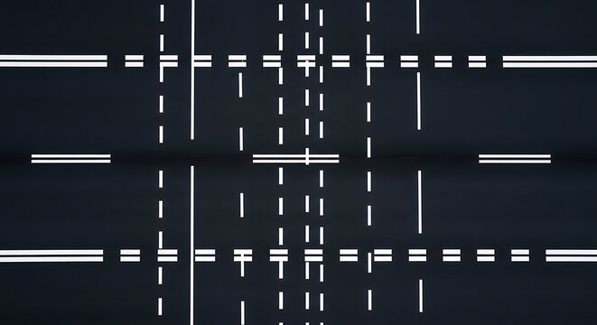 Aerial topdown perspective of a dark textured asphalt highway surface featuring painted white traffic lane marking on a clean empty interstate motorway bitumen pavement stretch.