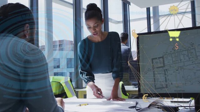 Woman pointing at blueprints, activating monitor showing cart and currency icons for retail design