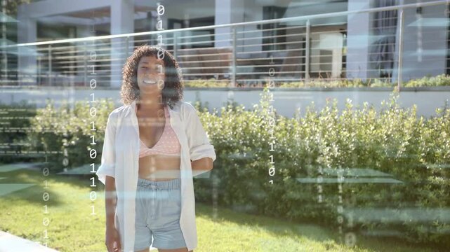 Adult woman turning to camera, causing tech binary overlay and reacting and smiling on house facade
