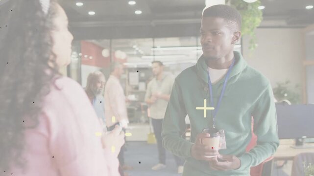 Woman speaking, man holding coffee adjusting grip, smiling, offering cup for sharing in office