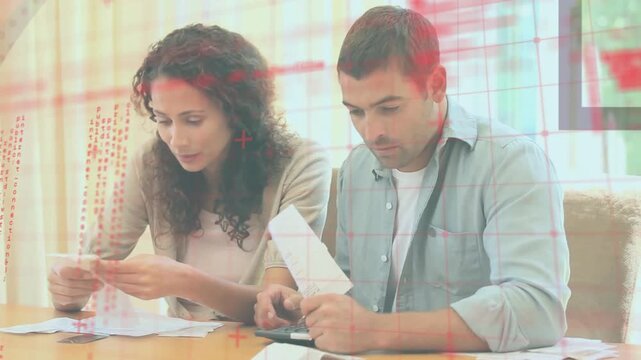 Couple reviewing bills and receipts, sorting papers, using calculator, managing home finances