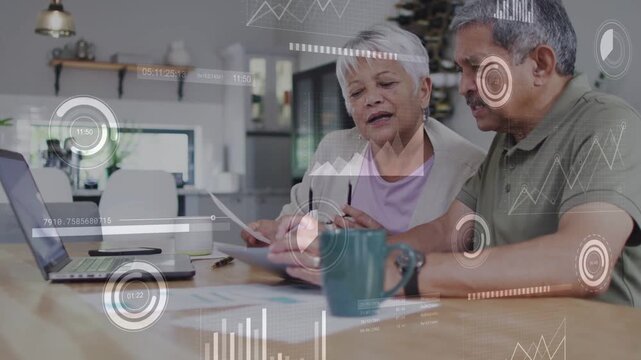 Seniors reviewing bills, woman reading paper and pointing, man leaning toward laptop, HUD overlays
