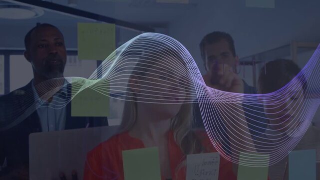 Four colleagues at glass, reacting to waveform sweep and rearranging sticky notes for business plan
