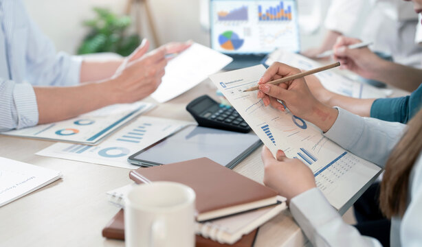 Business team analyzing financial reports and charts in office meeting.