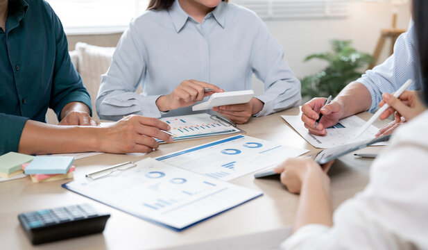 Close up of business people hands working with calculator and financial charts.