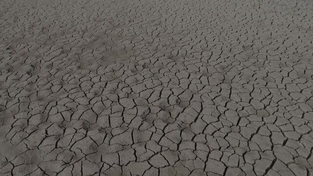 Aerial drone shot of cracked dry soil texture in drought landscape