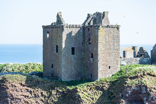 Dunnottar Castle near Stonehaven in Scotland, UK: Medieval stone ruins standing on a grassy coastal cliff above the sea, creating a dramatic historic landscape with rugged scenery and open views
