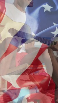 Vertical video: Musician playing guitar sand cam zooming as pal entering sharing under flag overlay