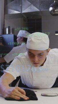 Vertical video: Chef reaching black cloth, wiping kitchen prep by scale for hygiene as HUD hovering