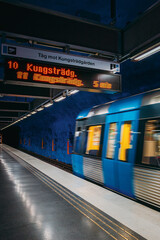 Obraz premium Blue Tunnelbana train arriving at Kungstradgarden metro station, Stockholm