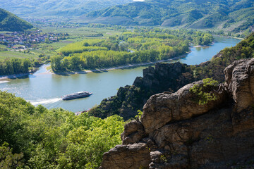 Obraz premium Scenic high angle view of a river cruise ship sailing on the Danube river through the beautiful Wachau Valley, Austria