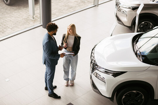 Salesperson discussing new car features with customer