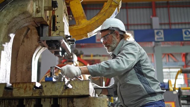Industrial worker operating machinery factory floor action scene busy environment close-up view manufacturing process
