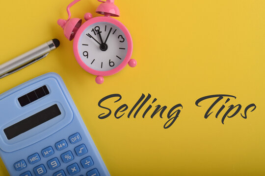 Selling Tips Concept with Calculator and Alarm Clock on Yellow Background
