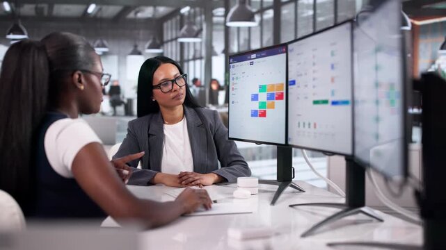 Human Resource Manager Guides Two Women Using HR Software