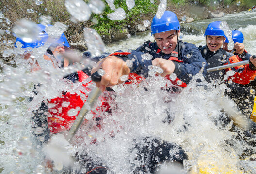 Extreme rafting in white water, splashes over the boat and the rafters