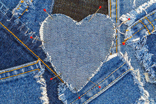 Crafting a heart from denim pieces using pins on a fabric surface during a sewing project