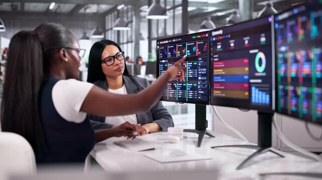 Two Women Work Together Using Cybersecurity Software