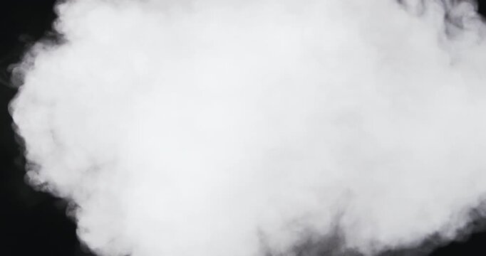 A dense round cloud of white smoke billows and expands against a black background, slowly rolling in soft puffy forms.