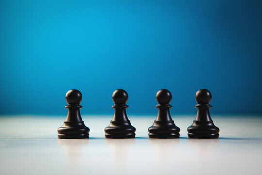 Black chess pieces on a blue background. The concept of leadership.