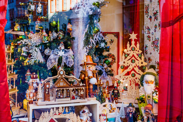Fototapeta premium Christmas market scene shows bright decorations with wooden toys and festive items in a shop window during the holiday season