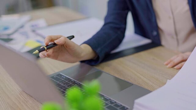 The focused hands typing on a laptop in a modern workspace. 