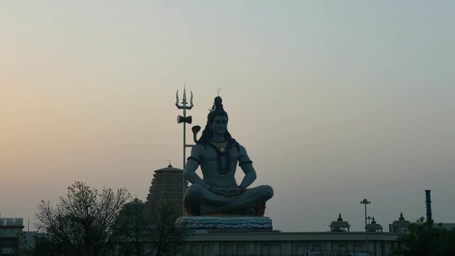 Timelapse video of Lord Shiva idol seated in a calm meditative pose with a temple structure in the background, representing devotion, inner peace, and Hindu religious heritage.