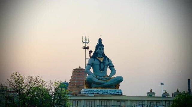 Lord Shiva seated in a meditative posture against a soft sunrise sky, symbolizing peace, spirituality, devotion, and divine energy in Hindu culture.