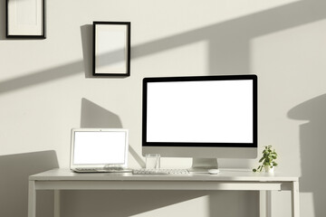 Fototapeta premium Modern programmer's workplace with computer monitor, laptop and glass of water in office