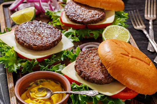 beef cheeseburgers with brioche buns on a tray