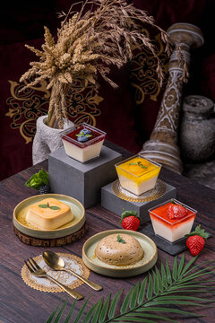 a group of desserts such as strawberry pana cota, mango pana cota, blueberry pana cota, sugar apple pudding and also caramel pudding which are served and arranged perfectly