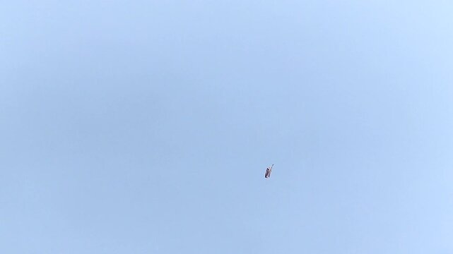 Single kite drifting in open blue sky, minimal and peaceful scene. Ideal for freedom, childhood, aspiration, leisure, outdoor lifestyle, and conceptual background storytelling.