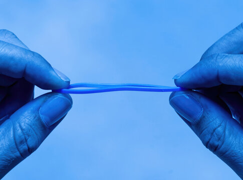 A pair of human hands holding a blue toothbrush, ready for dental hygiene