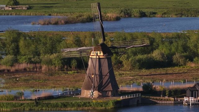 Traditional dutch windmill spinning in kinderdijk landscape