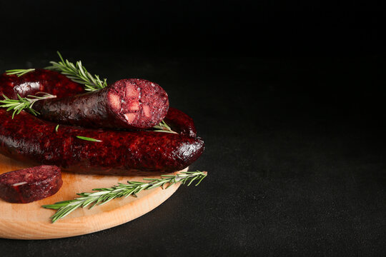 Tasty blood sausage on black background