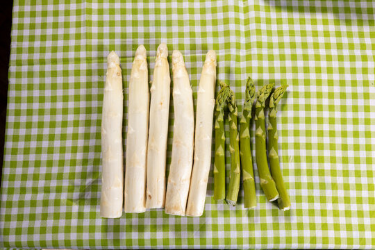Spargel Wei&szlig; und gr&uuml;n auf einer gemusterten Tischdecke 