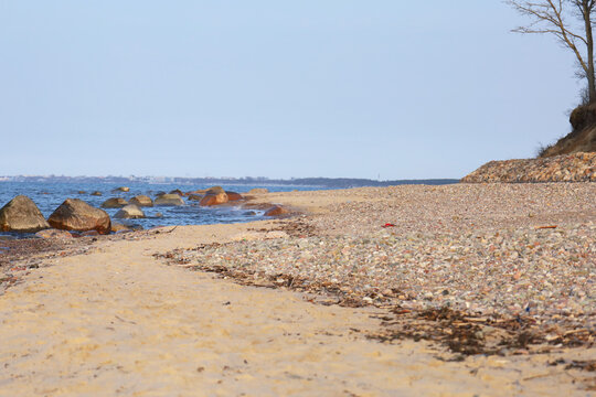 Sunlit beach with pebbles and scattered rocks
