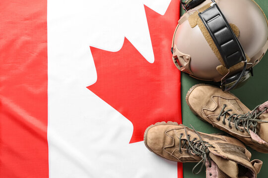 Canadian flag, military boots and helmet on green background